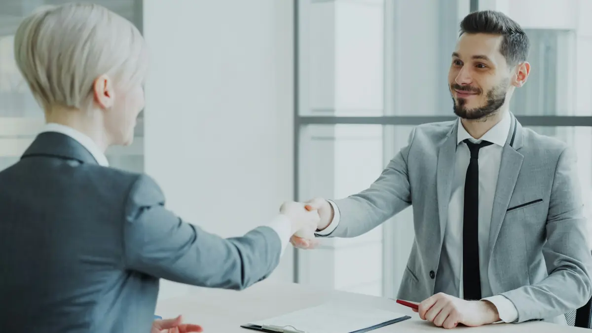 Employer and candidate shaking hands after a successful hire